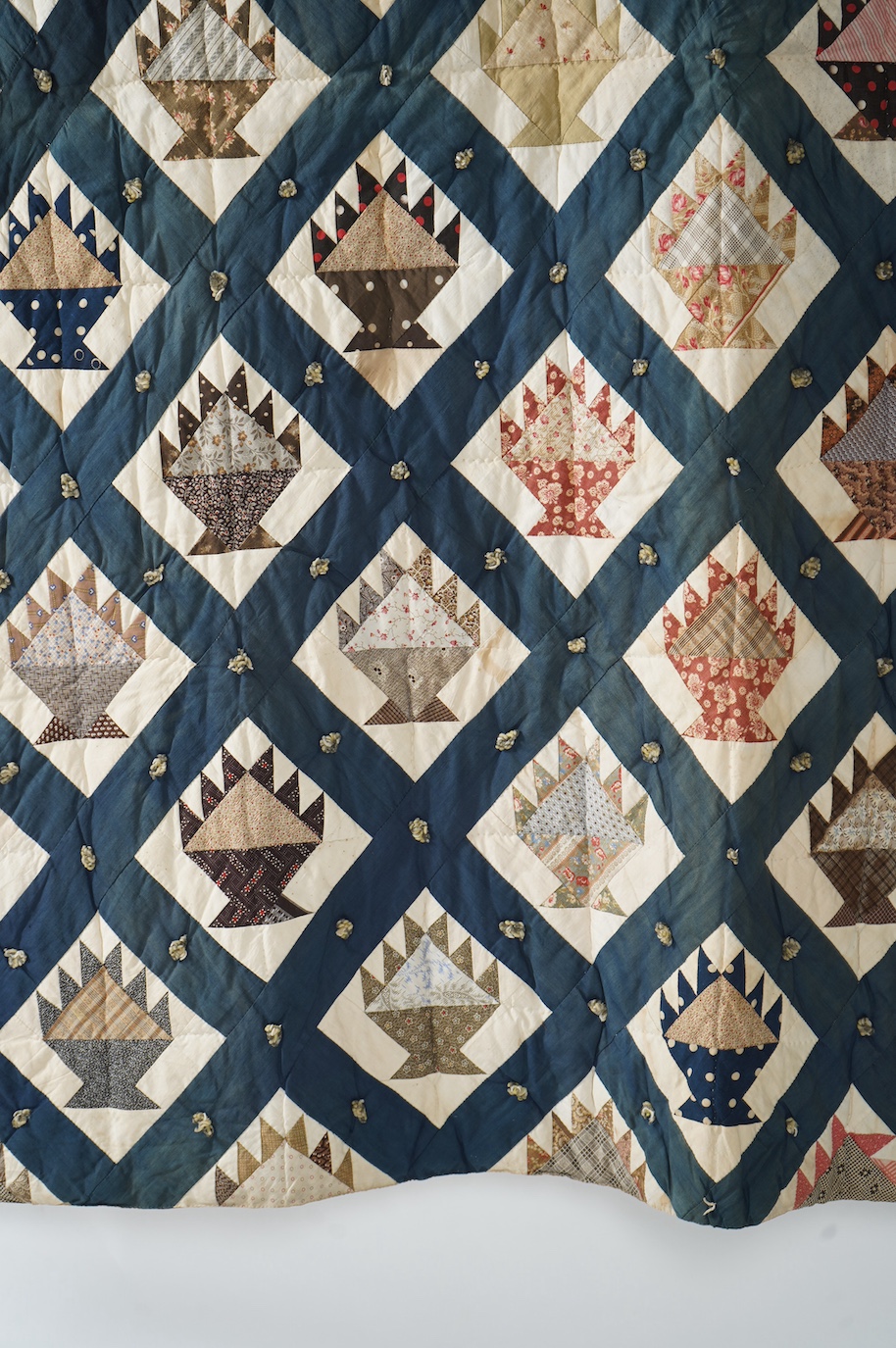 A bold handsome, American, Vermont 1865 (Civil War) ‘basket’ and lattice, hand quilted and piece tied bedcover, with an ornate floral backing. Worked with a plain navy cotton lattice border around central stylised printe